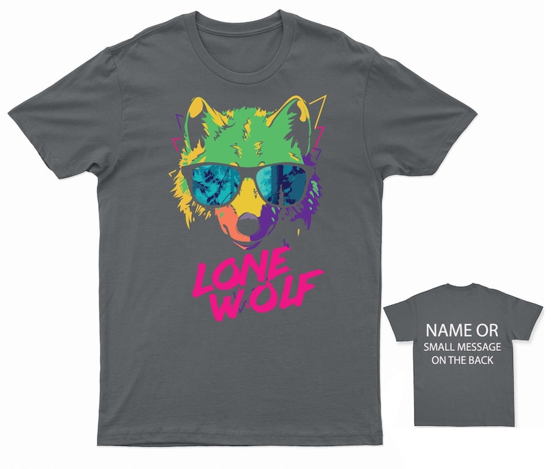 May include: A dark gray t-shirt with a colorful graphic of a wolf wearing sunglasses. The text "LONE WOLF" is printed in pink below the wolf.