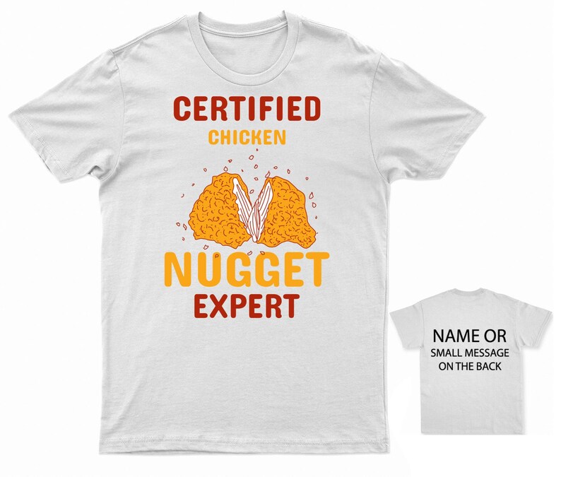 Op de afbeelding: Wit T-shirt met de tekst "CERTIFIED CHICKEN NUGGET EXPERT" in rood en oranje. Een cartoon afbeelding van een kipnugget bevindt zich in het midden van het shirt. De achterkant van het shirt is wit met de tekst "NAME OR SMALL MESSAGE ON THE BACK" in zwart.