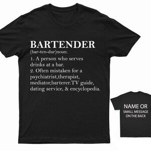 May include: Black t-shirt with white text that reads "BARTENDER (bar-ten-dur) noun. 1. A person who serves drinks at a bar. 2. Often mistaken for a psychiatrist, therapist, mediator, barterer. TV guide, dating service, & encyclopedia."