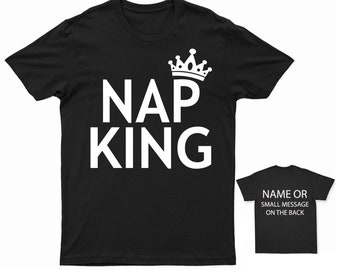 Könnte beinhalten: Schwarzes T-Shirt mit weißem Text "NAP KING" und einer Krone über dem Text. Die Rückseite des Shirts bietet Platz für einen Namen oder eine kleine Nachricht.