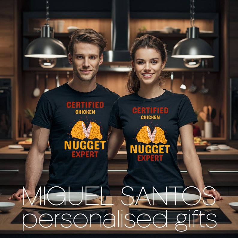 Op de afbeelding: Twee zwarte T-shirts met een afbeelding van een kipnugget en de tekst "Certified Chicken Nugget Expert".