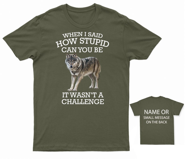 K&ouml;nnte beinhalten: Ein gr&uuml;nes T-Shirt mit einer wei&szlig;en Wolfgrafik und dem Text "WHEN I SAID HOW STUPID CAN YOU BE IT WASN'T A CHALLENGE". Auf der R&uuml;ckseite des Shirts steht "NAME OR SMALL MESSAGE ON THE BACK".