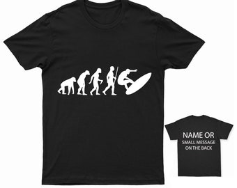 Puede incluir: Camiseta negra con una silueta blanca de la evolución del hombre, que termina con un surfista montando una ola. El texto "NAME OR SMALL MESSAGE ON THE BACK" está en una camiseta negra más pequeña.