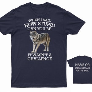 K&ouml;nnte beinhalten: Marineblaues T-Shirt mit einem wei&szlig;en Wolf-Motiv und dem Text "WHEN I SAID HOW STUPID CAN YOU BE IT WASN'T A CHALLENGE".