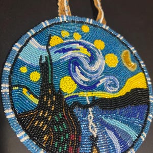 May include: A round beaded necklace with a blue, yellow, and white design. The design is a recreation of Vincent van Gogh's "Starry Night" painting.
