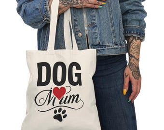 May include: Cream-colored tote bag with the words "DOG Mum" in black script and a red heart. A black paw print is below the text. The bag has two white handles.