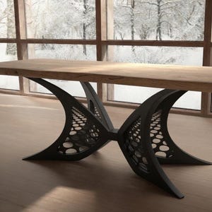 Puede incluir: Una mesa de comedor rectangular con un tablero grueso de madera natural de tono claro y acabado liso. La base consta de dos soportes de metal negro con forma curva de media luna y un diseño perforado de patrón circular.