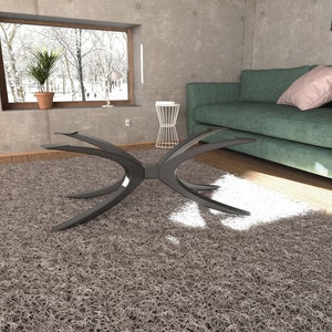 Puede incluir: Una mesa de centro moderna negra con un dise&ntilde;o curvo &uacute;nico se encuentra sobre una alfombra de pelo gris en un sal&oacute;n. La mesa tiene un estilo elegante y minimalista y es perfecta para un hogar contempor&aacute;neo.