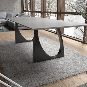 May include: A modern dining table with a gray concrete top and black metal legs. The legs are shaped like a crescent moon and are attached to the underside of the table top.