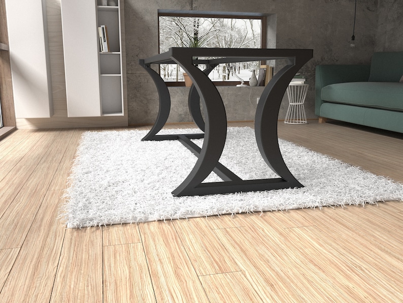 Op de afbeelding: Een eettafel met een plat rechthoekig blad ondersteund door twee zwarte metalen poten met een gebogen, halvemaanvormig ontwerp. De basis bevat een horizontale steunbalk die de twee poten verbindt voor structurele stabiliteit van het frame.