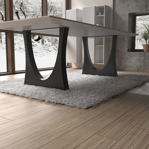 May include: A modern white dining table with a black metal base. The table is set on a white shag rug in a room with large windows and wooden floors.