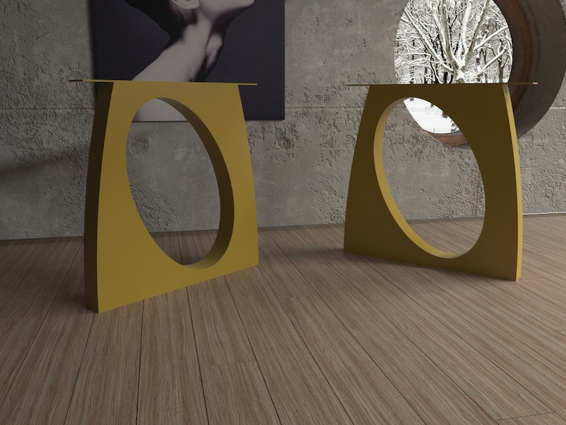 May include: Two gold metal table bases with a unique oval cutout design. The bases are on a wood floor.