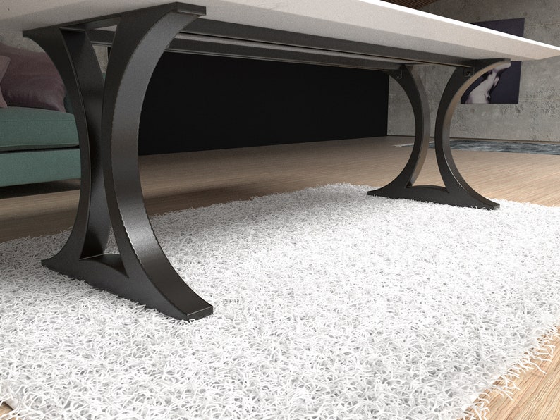 May include: A table with a smooth white rectangular top supported by two black metal legs. Each leg features a curved, arch-like design that flares outward at the base and top, providing a stable foundation for the tabletop surface above.