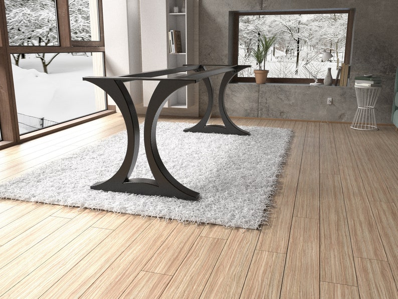May include: A black metal table base featuring two curved, C-shaped supports connected by a horizontal frame. The structure is designed to hold a tabletop, showcasing a sleek, open design with a smooth finish and a wide, stable base for support.