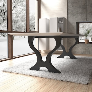 May include: A light wood dining table with a rectangular top and black metal legs. The legs have a unique, curved design. The table is set on a white rug in a room with large windows.