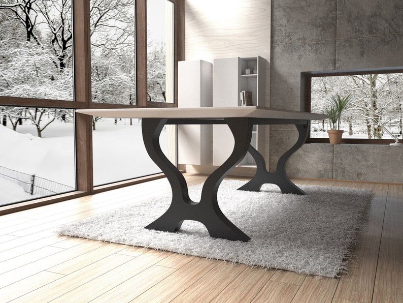 May include: A light wood dining table with a rectangular top and black metal legs. The legs have a unique, curved design. The table is set on a white rug in a room with large windows.