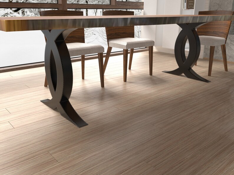 Puede incluir: Una mesa de comedor de madera larga con una base de metal negro. La base est&aacute; hecha de dos piezas de metal curvadas que se unen en el medio. La mesa est&aacute; puesta con cuatro sillas.