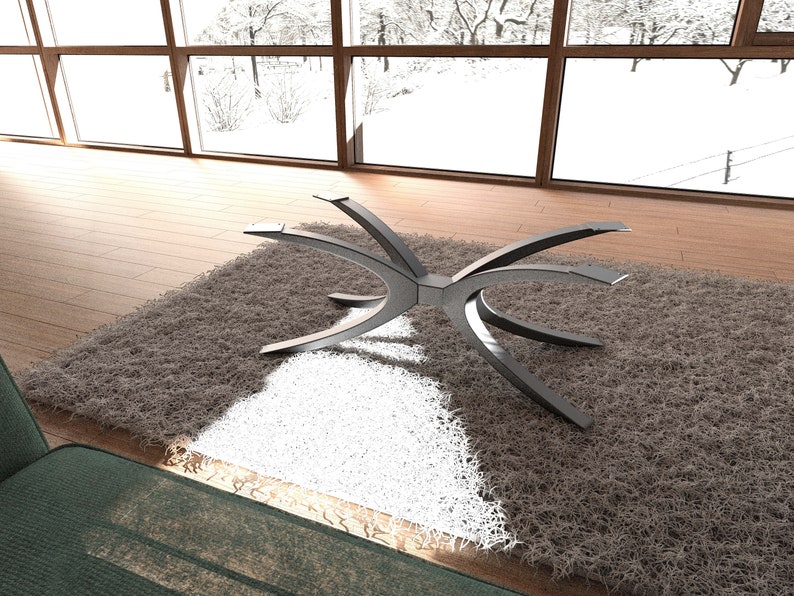 Puede incluir: Una base de mesa de metal plateado con un dise&ntilde;o curvo &uacute;nico. La base est&aacute; sentada sobre una alfombra de pelo marr&oacute;n y blanco.