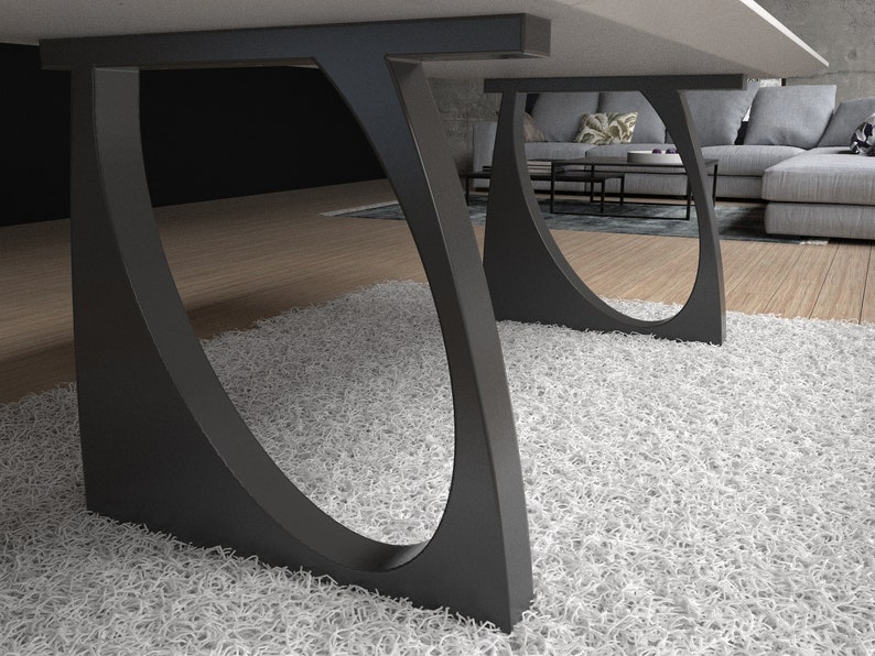 May include: Close-up of a black, curved table leg with a rounded opening. The leg is on a white shag rug.