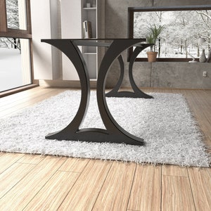 May include: A dining table featuring a flat rectangular top supported by two distinct black metal bases. Each base has a curved, hourglass-like silhouette that flares outward at the top and bottom, providing a stable foundation for the table surface.