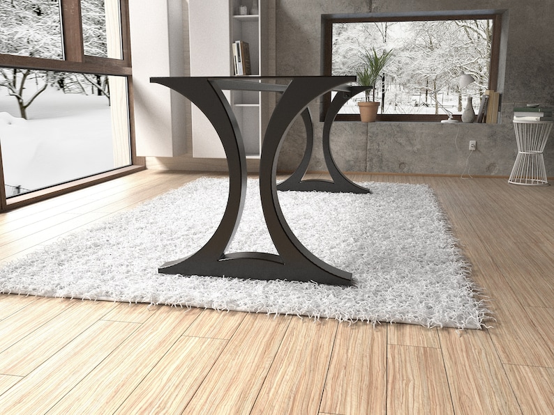 May include: A dining table featuring a flat rectangular top supported by two distinct black metal bases. Each base has a curved, hourglass-like silhouette that flares outward at the top and bottom, providing a stable foundation for the table surface.