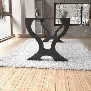 May include: A black glass table with a unique, abstract, curved base. The table is sitting on a white shag rug in a room with a large window.
