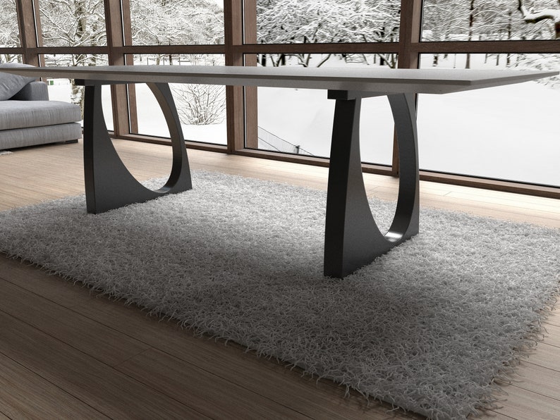 May include: A modern dining table with a white top and black, curved legs. The table is set on a gray rug in front of a window.