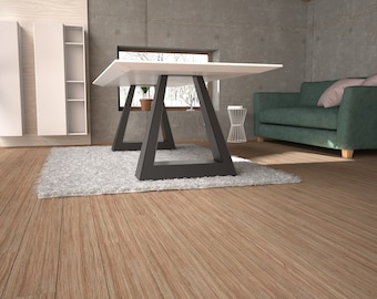 May include: A white table with a black triangular base sits on a gray rug in a modern living room. A green sofa with pillows is in the background.