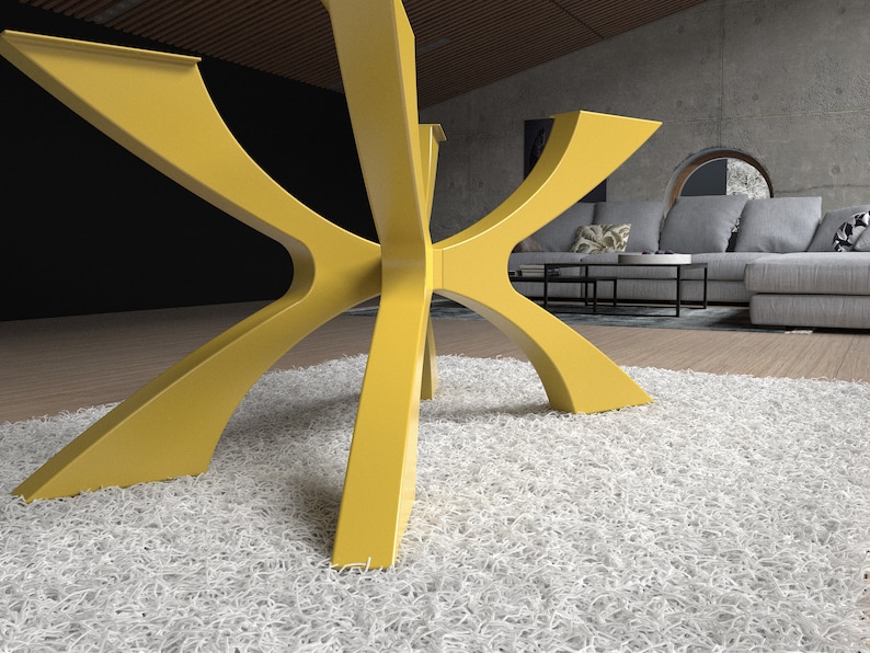 May include: A modern, yellow table base with a unique, geometric design. The base features six curved legs that meet in the center, creating a star-like shape. The table base is made of a solid material and is set on a white shag rug.