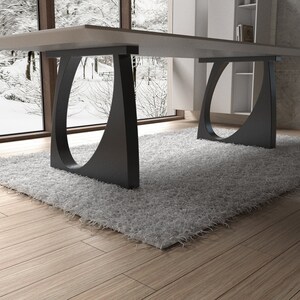 May include: A modern dining table with a white top and black, curved legs. The table is set on a white shag rug.
