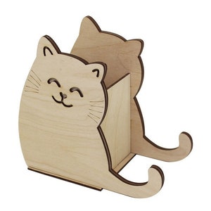Op de afbeelding: Houten kattenvormige bureau-organizer met een uitsparing voor pennen of potloden. De kat heeft een glimlachend gezicht en is gemaakt van lichtbruin hout.