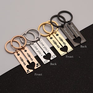 May include: Four sets of matching keychains with a heart design. Each keychain has two pieces, one with a heart cut out and the other with a heart that fits inside. The keychains are engraved with the text "Love you x" and "The special moment" along with a date and a sound wave pattern.