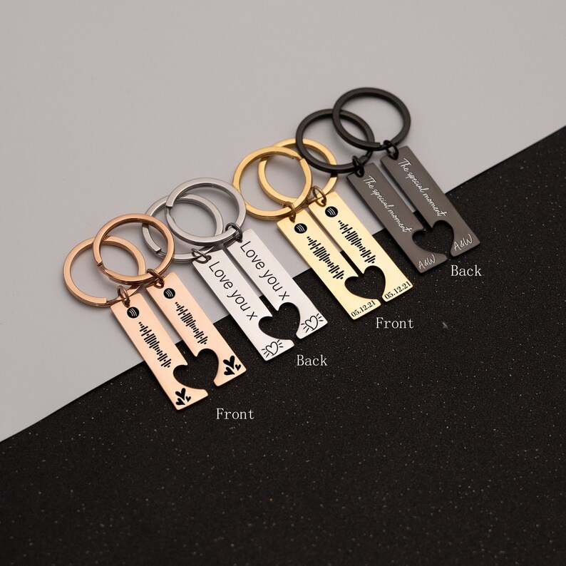 May include: Four sets of matching keychains with a heart design. Each keychain has two pieces, one with a heart cut out and the other with a heart that fits inside. The keychains are engraved with the text "Love you x" and "The special moment" along with a date and a sound wave pattern.