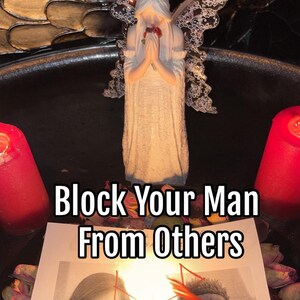 May include: A white figurine of an angel with wings, holding a red rose, is placed in the centre of a black tray. Two red candles are on either side of the tray. A white piece of paper with the text "Block Your Man From Others" is in front of the angel.