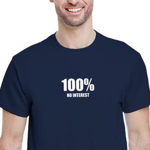 May include: A navy blue t-shirt with the text "100% NO INTEREST" printed in white. The shirt has a crew neck design and is likely made from a soft fabric.