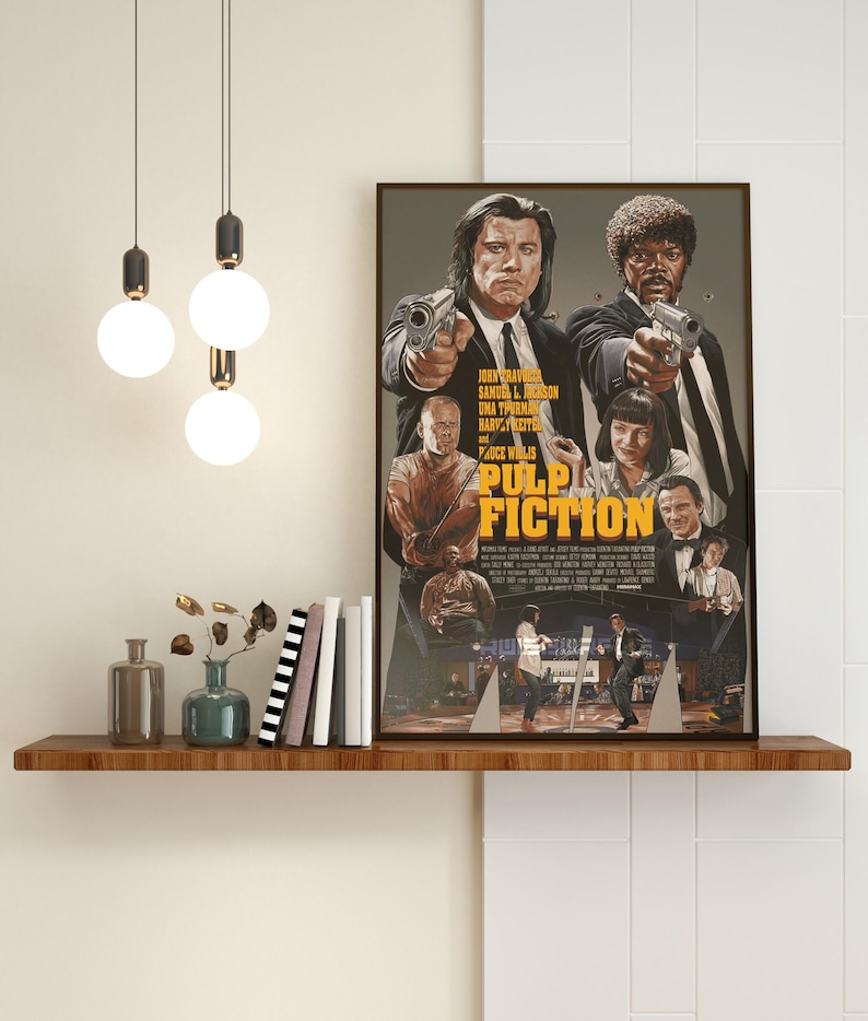May include: A vintage movie poster for the film Pulp Fiction, featuring John Travolta, Samuel L. Jackson, Uma Thurman, and Bruce Willis. The poster is in a brown frame and is hanging on a wall.