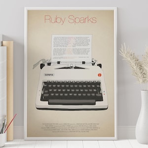 May include: A minimalist poster with the title "Ruby Sparks" in red text. The poster features a vintage white typewriter with a sheet of paper in it. The typewriter has the word "Olympia" printed on it.