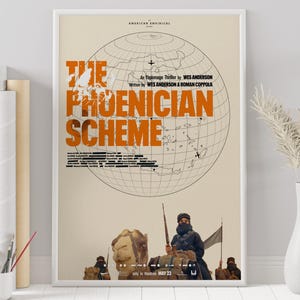 Może przedstawiać: Oprawiony plakat filmowy do filmu "The Phoenician Scheme" w białej ramie. Plakat zawiera pomarańczowy tekst na beżowym tle, z grafiką globu i sceną ludzi na wielbłądach. Tekst zawiera "American Empirical" i "An Espionage Thriller by Wes Anderson."