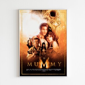 May include: Movie poster for "The Mummy" featuring a group of people in a desert setting. The poster has a gold and black color scheme with the title "The Mummy" in large, bold letters.
