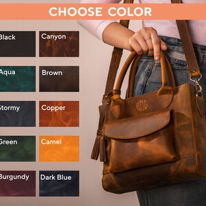 Op de afbeelding: Een bruine leren handtas met een voorvak en een kwastje. De tas heeft een handvat aan de bovenkant en een schouderriem. De tekst "CHOOSE COLOR" staat bovenaan, met kleuropties: Zwart, Canyon, Aqua, Bruin, Stormachtig, Koper, Groen, Camel, Bourgondi&euml; en Donkerblauw.