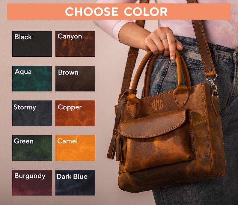 Op de afbeelding: Een bruine leren handtas met een voorvak en een kwastje. De tas heeft een handvat aan de bovenkant en een schouderriem. De tekst "CHOOSE COLOR" staat bovenaan, met kleuropties: Zwart, Canyon, Aqua, Bruin, Stormachtig, Koper, Groen, Camel, Bourgondi&euml; en Donkerblauw.