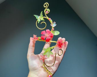Gold arm jewelry with hibiscus and greenery