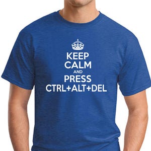 May include: A royal blue t-shirt featuring the white text "KEEP CALM AND PRESS CTRL+ALT+DEL", with a crown graphic above. The shirt has short sleeves and a crew neck.