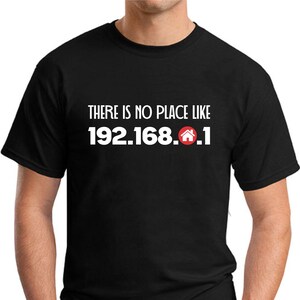 May include: Black t-shirt featuring the white text "THERE IS NO PLACE LIKE 192.168.0.1" and a red house icon. The shirt has a crew neck.