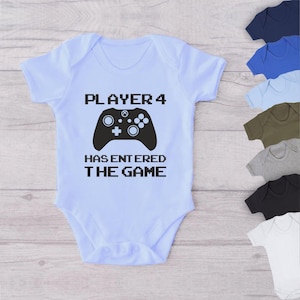May include: Light blue baby bodysuit with black text that reads "PLAYER 4 HAS ENTERED THE GAME" and a black video game controller graphic.