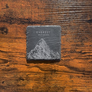 May include: A black slate coaster with a white outline of Mount Everest and the text "EVEREST 8849 METRES".