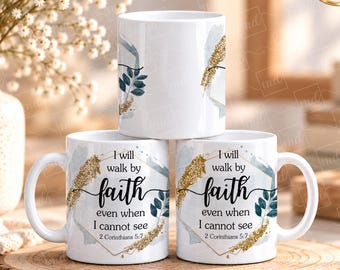 Puede incluir: Tres tazas de cerámica blanca con un marco geométrico dorado, hojas de color verde oscuro y detalles de purpurina dorada. El texto dice: I will walk by faith even when I cannot see 2 Corinthians 5:7.