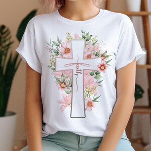May include: White t-shirt with a floral design featuring a white cross with the word "faith" written on it.