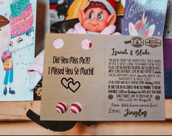 May include: A brown card with a message from an elf to Isaiah and Blake. The card says "Did you miss me?!? I missed you so much!!" and "I'm back from the North Pole once again, after a very long year away from you! Please stay on your best behaviour, and follow the rules when I leave each night. I give my daily report to Santa. These reports help Santa write his Naughty & Nice List! So be good and help spread some Holiday cheer! Be sure to be on the lookout for me each morning to find me. Remember I leave on Christmas Eve until next year again. Don't forget, not to touch me or I will lose my magic!! Now let's have some fun! Love, Jingles".