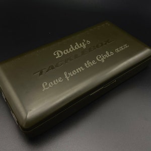 Può includere: Una scatola da pesca verde con le parole "Daddy's Tacklebox" e "Love from the Girls xxx" incise sul coperchio.